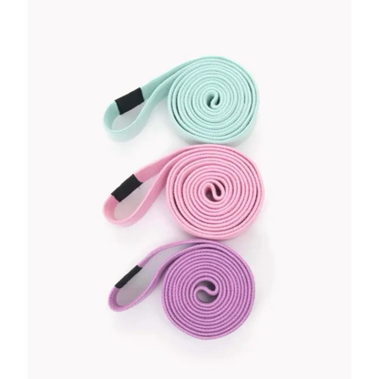 Drie opgerolde yogabandjes in pastelkleuren mintgroen, roze en lavendel.