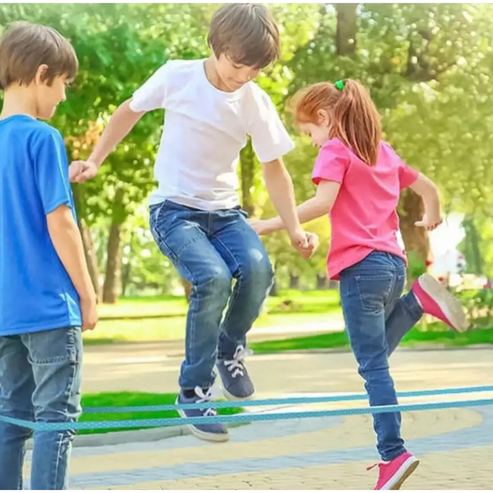 Kinderen spelen hinkelbaan op een verhard stuk buiten.