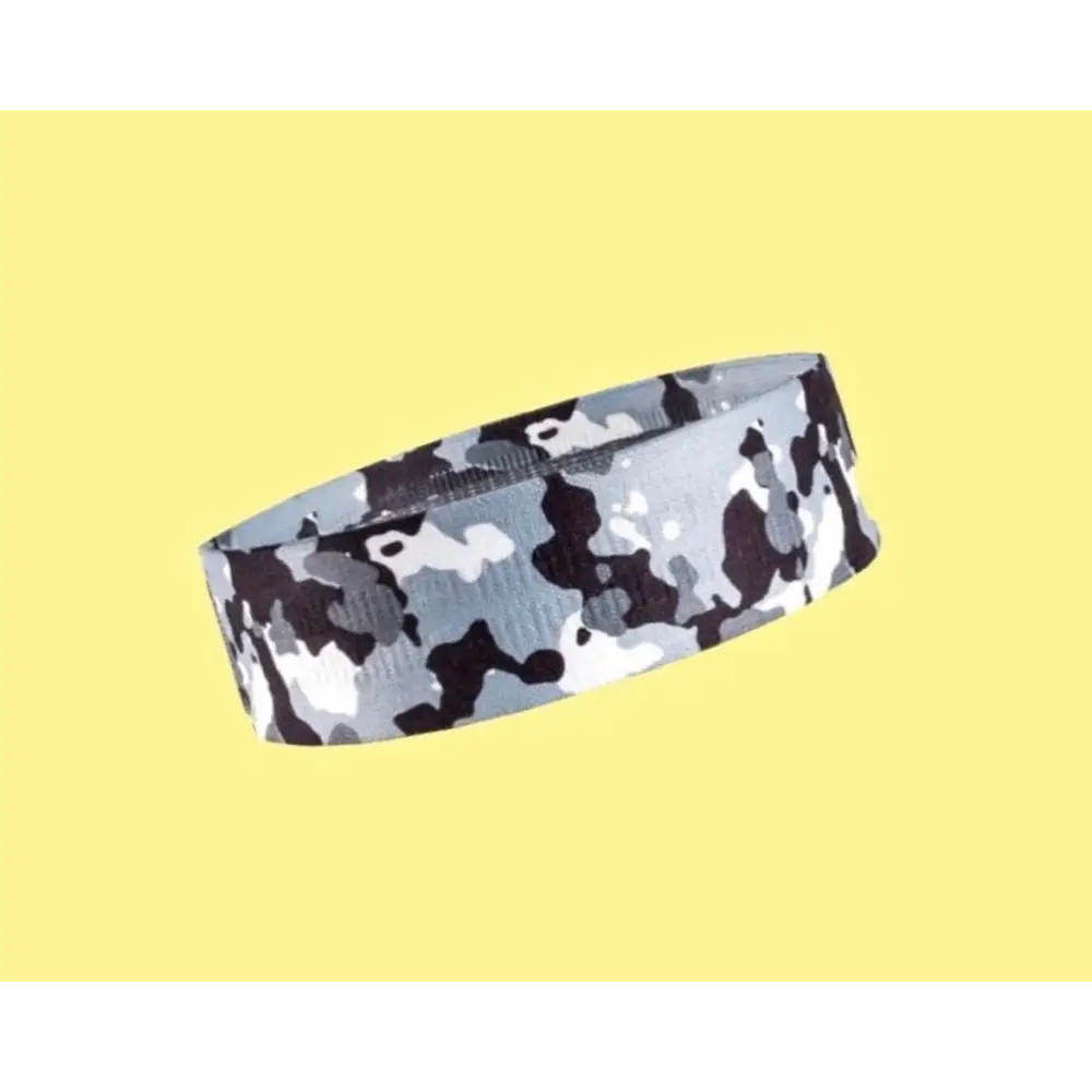 Polsband of armband met camouflagepatroon in grijstinten, zwart en wit.