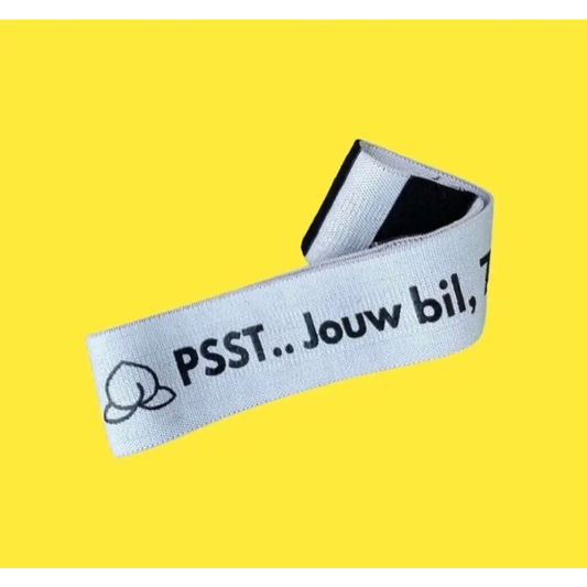 Wit lint of tape met ’PSST. Jouw bil,’ erop gedrukt, naast een klein tekstballonnetje.